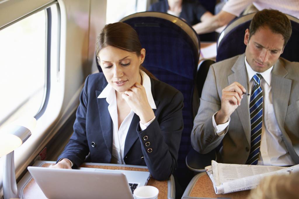 Businesswoman Commuting To Work On Train And Using Laptop