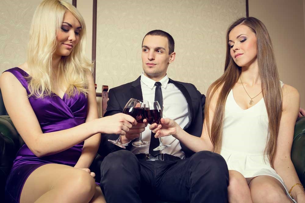Discover Great Luxurious Brothel Services Around The World one man and two sexy women having a drink at a bar